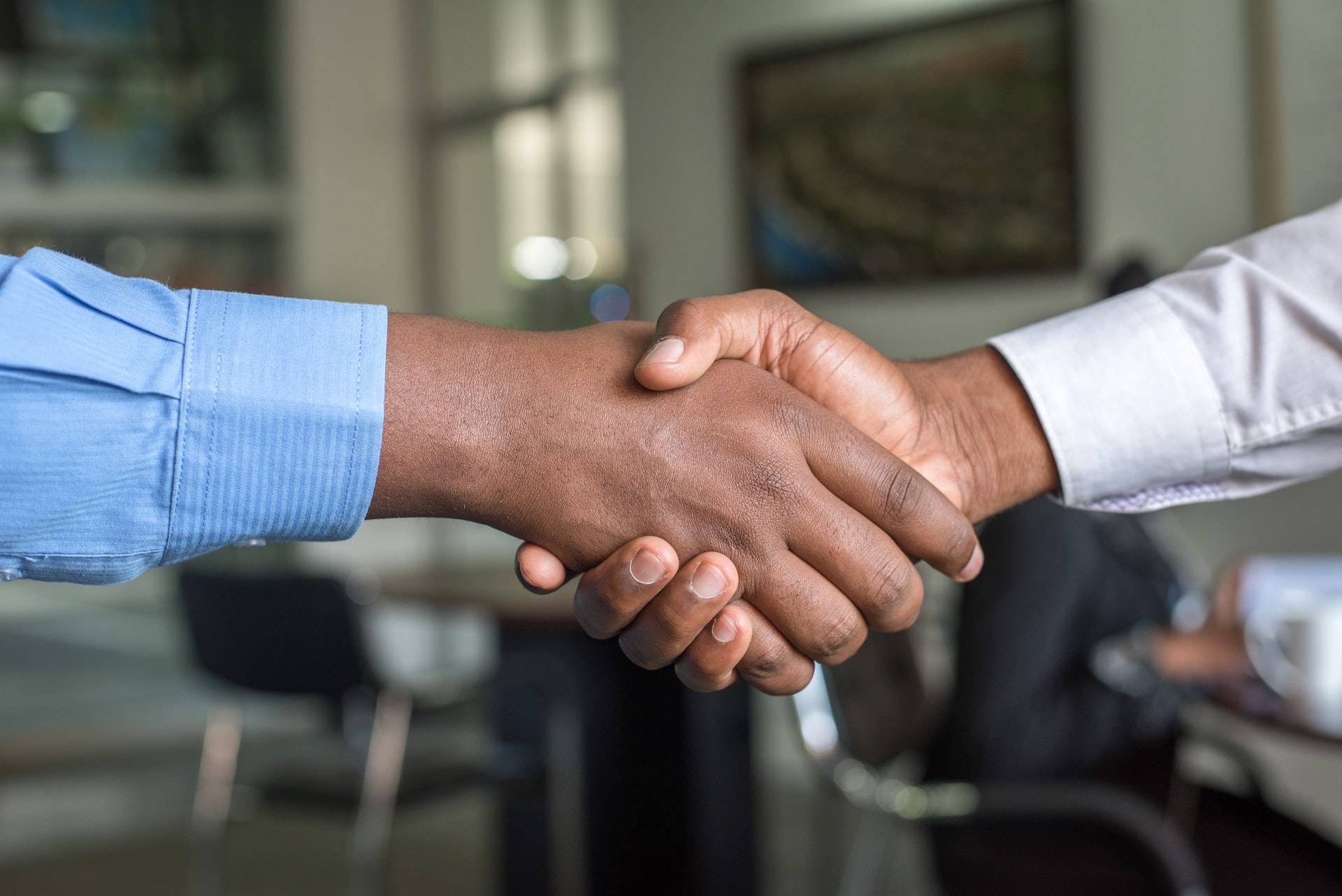 Two men shaking hands after deciding to sell the family business