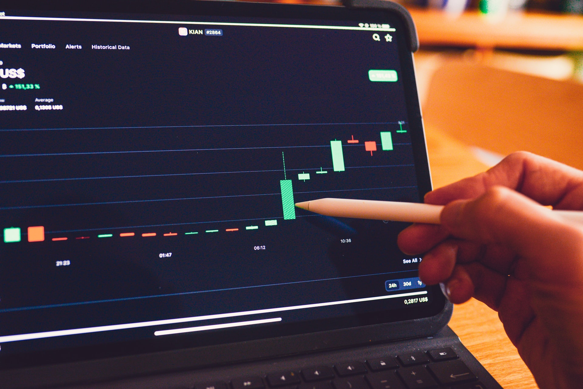 A man with a pencil pointing at a rising stock on a chart